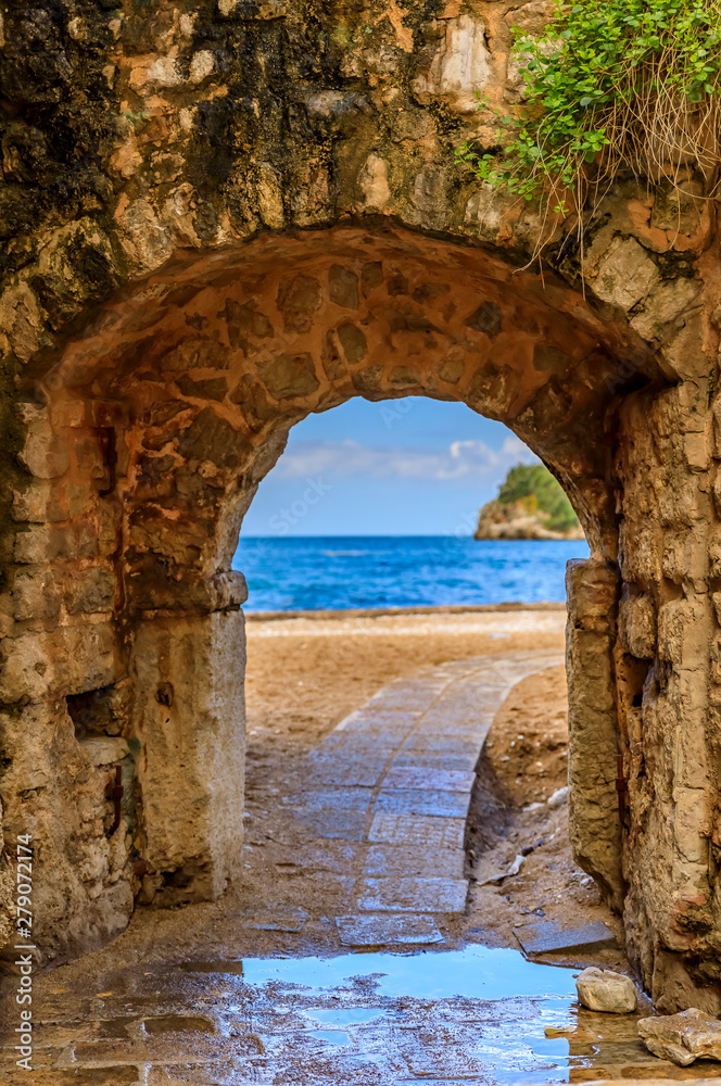 Poster picturesque brick arch and path of the medieval old town open onto the adriatic sea in the balkans i