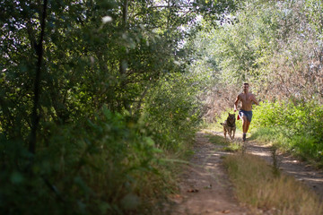 runner running across the field with his dog