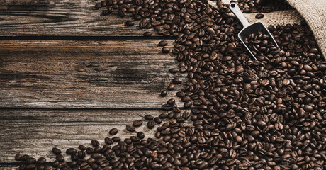 coffee beans with coffee spoon on brown wooden background