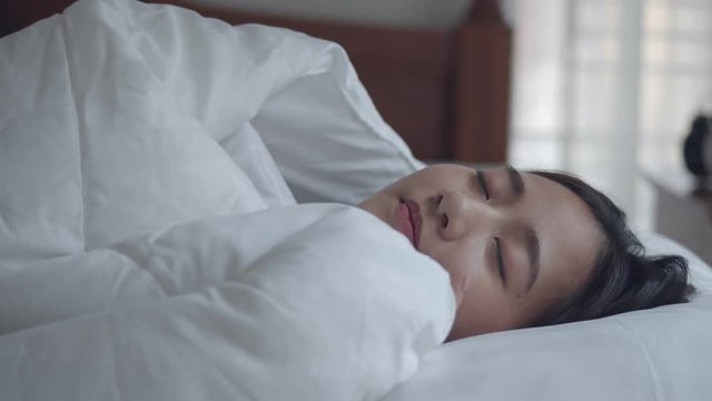 Young Asian women sleeping well in comfortable in the bedroom at home.