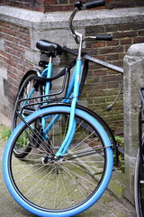 An einem Geländer geparktes hellblaues Fahrrad