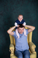 Father and Daughter Posing on Armchair in Studio