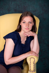 Beautiful Woman Sitting on Big Armchair in Studio