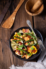 Pasta salad with green asparagus, olives and parma ham