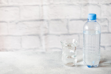 Plastic transparent water bottle on grey background with copy space.