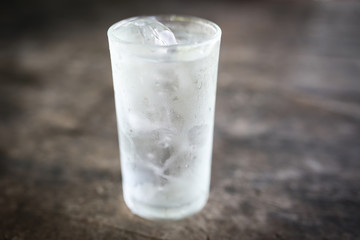 Cool water in glass on wooden table.