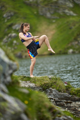 Woman kickbox fighter training by the lake