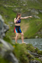 Woman kickbox fighter training by the lake