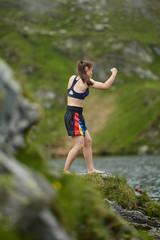 Woman kickbox fighter training by the lake