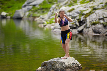 Woman kickbox fighter training by the lake