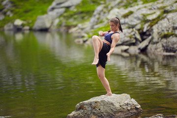 Woman kickbox fighter training by the lake