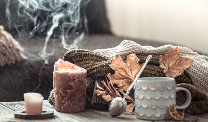Cozy autumn morning breakfast in bed still life scene. Steaming cup of hot coffee, tea standing near window. Fall.