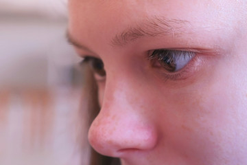 Girl is reading something, eyes close up view. Young woman is moving her eyes during reading a book or smartphone, side view.