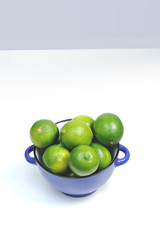 Lime Citrus Fruits in a bowl over white background