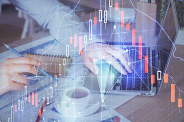 Forex graph with businessman working on computer in office on background. Concept of hardworking. Multi exposure.