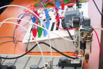 Electric educational device white color with the wires on the table