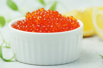 A small ceramic bowl with red caviar