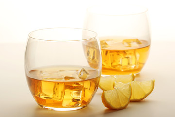 Two glasses with whiskey with ice cubes