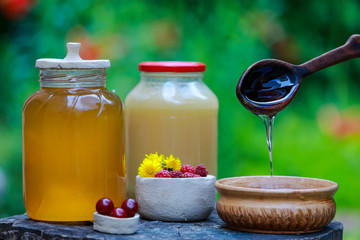 fresh sweet honey dripping in a wooden spoon in a ceramic bowl