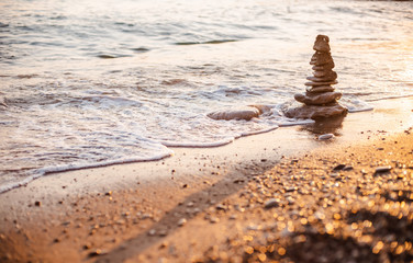 Fototapeta na wymiar stones of the pyramid on the beach symbolize the concept of Zen, harmony, balance.