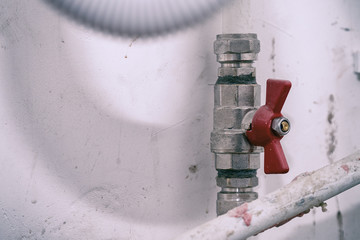 Tap with red handle on white plastic water pipe
