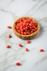 Frische Goji-Beeren Superfood in Bambus Holzschale auf Marmor Hintergrund