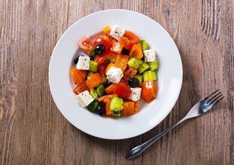 Greek salad of fresh cucumber, tomato, sweet pepper, feta cheese and olives with olive oil and spices. Healthy food, top view