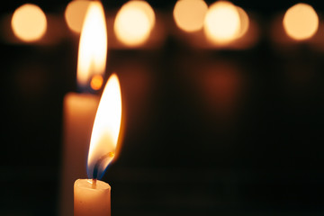 A single burning candle isolated with black background