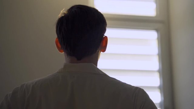 Doctor or lab person looking at the sun through hospital or lab window