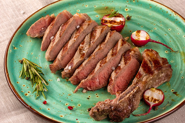 Juicy medium rare beef steak with herbs spices and salt.