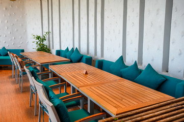 Wooden dining table with green pillows on sofa
