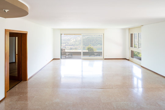 Empty living room with windows and lake view