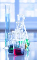 Different laboratory glassware with color liquid and with reflection. Tube, flask and beaker