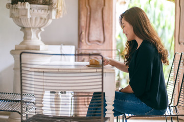 A beautiful asian woman holding and enjoyed drinking hot coffee in cafe