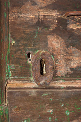 Iron keyhole with rust on an old wooden door