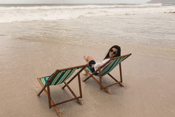 Young woman relaxing on sun lounger and looking at camera