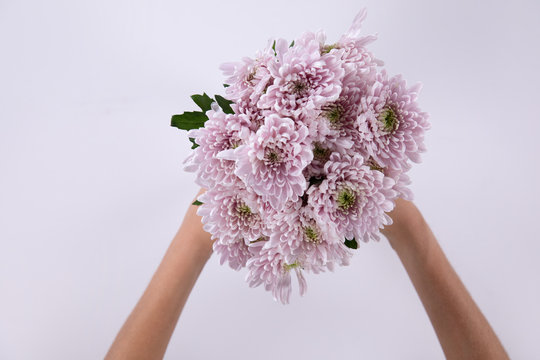 Woman holding a pink bouquet of flower between her hands