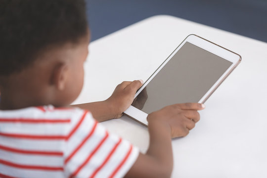 Schoolboy using digital tablet at desk 
