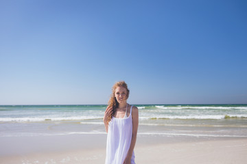 Fototapeta na wymiar Beautiful woman standing at beach on a sunny day