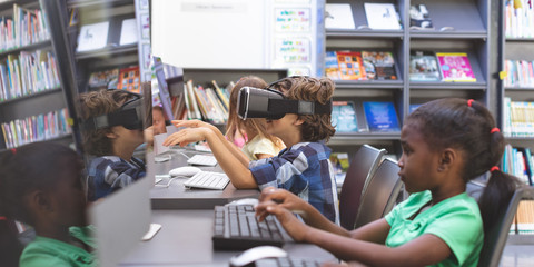 Schoolboy using virtual reality headset in computer room