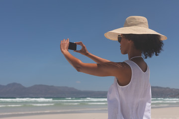 Fototapeta premium Young woman talking selfie at beach on sunny day