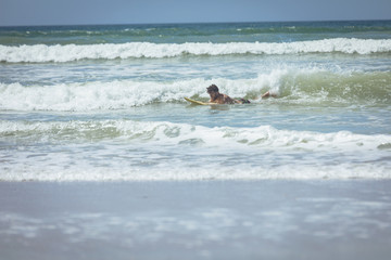 Young male surfer enjoying surfing at beach 