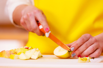 Woman housewife in kitchen cutting apple fruits