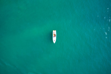 Yacht white blue awning on turquoise water, top view. Aerial photography with drone. 