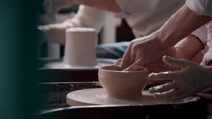 Adult sculptor working with raw clay in cozy class room or work place studio with soft daylight inside. Happy family spending free weekend time together and making craft objects for fun