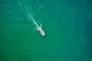 Yacht white blue awning on turquoise water, top view. Aerial photography with drone. 