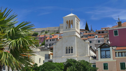 Fototapeta na wymiar Colourful historic city of Sibenik with palm trees and church, Croatia