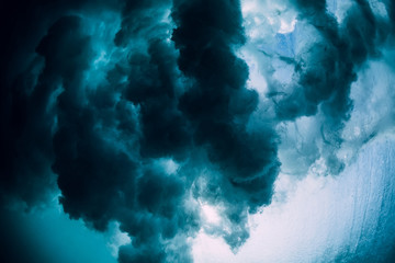 Barrel wave underwater with air bubbles and sun light. Ocean in underwater