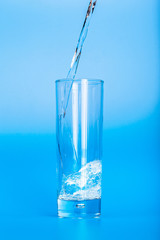 Close up pouring purified fresh drink water from the bottle on table