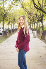 Beautiful woman standing aside in tree alley